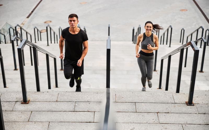 Happy sporty couple going jogging on stairs