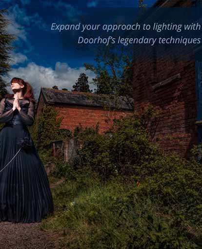 photography lighting workshop - model wearing black gown in front of a cottage