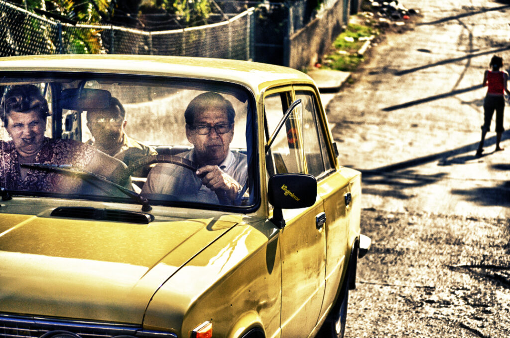 image of three people in a yellow car
