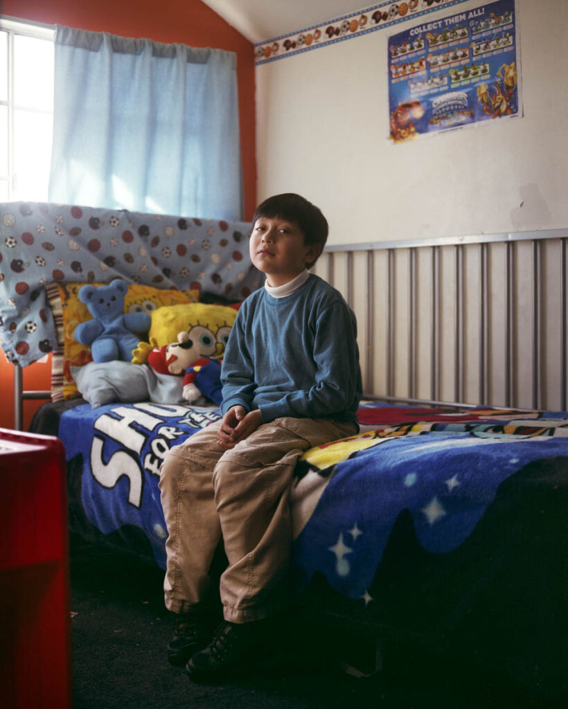 portrait of boy sitting on a bed