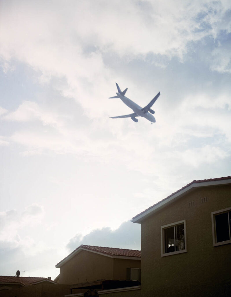 a plane flying over the houses