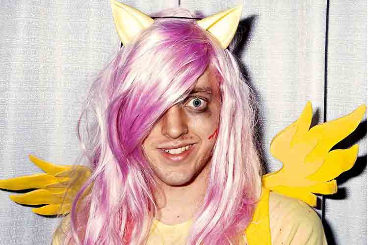 man wearing yellow fairy costume and pink hair with blood makeup