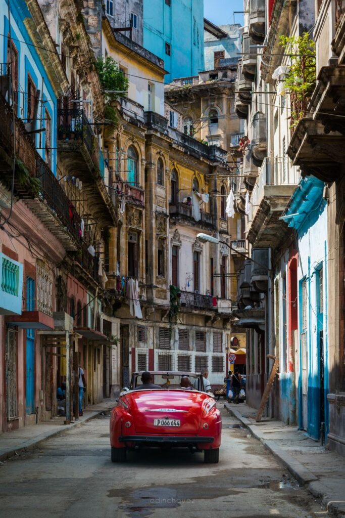 image of a red car on a street amidst buildings