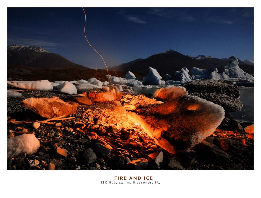 campfire beside a snowy riverside