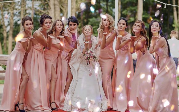 bride with 8 bridesmaids giving a flying kiss to the camera