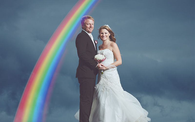 bride and groom portrait on a sky background with rainbow overlay