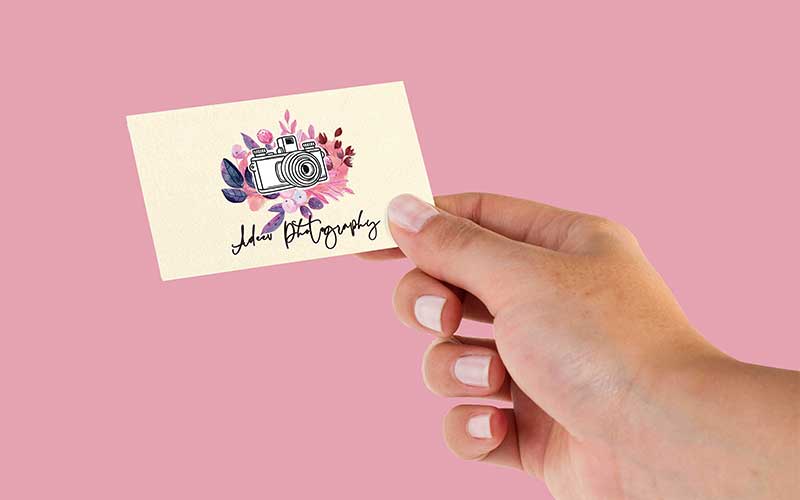 A business card against a pink background