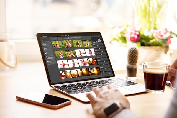 A photographer using a photo culling software on his laptop