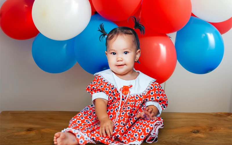 baby with red blue balloons background