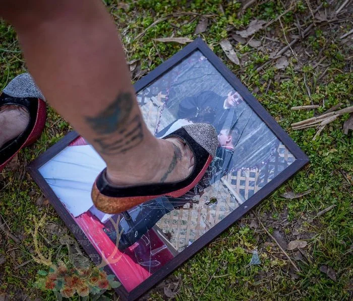 woman smashing a photo frame with her heels