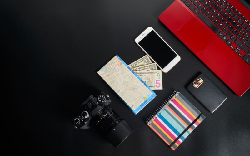 Composition of camera near photos, money and laptop