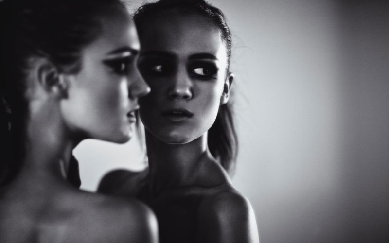 Black and white image of a girl looking in the mirror