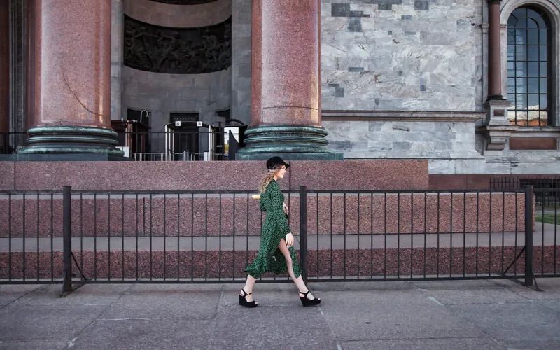 photo of a woman strolling past a building- street photography