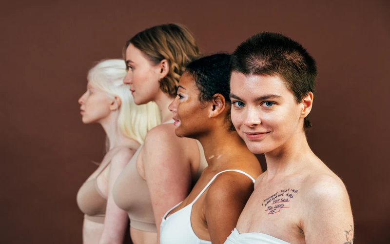 Four women of different body types standing in profile, celebrating diversity in fine art figure photography