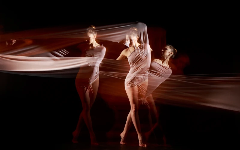 Long exposure artistic figure photography showing a dancer wrapped in flowing fabric