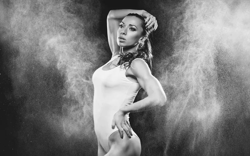 Black and white portrait of a woman wrapped in fabric with a soft powder effect around her