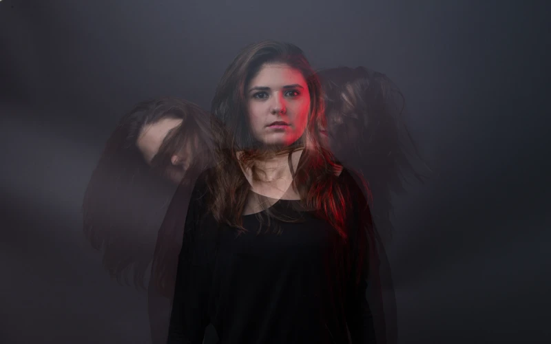 Woman surrounded by mist with red lighting
