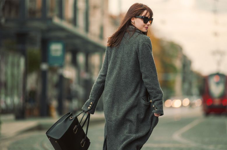 woman walking, looking over the shoulder wearing shades, a winter jacket