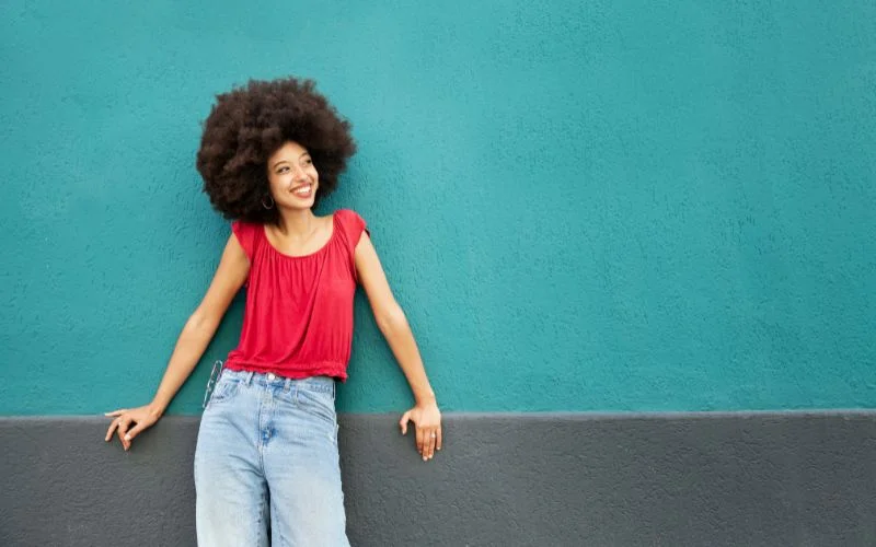 girl wearing red shirt leaning on wall