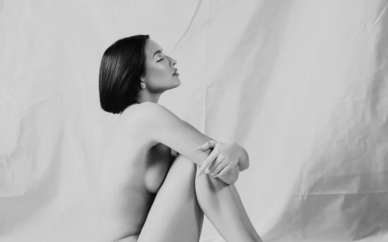 black and white nude photography of a woman sitting down