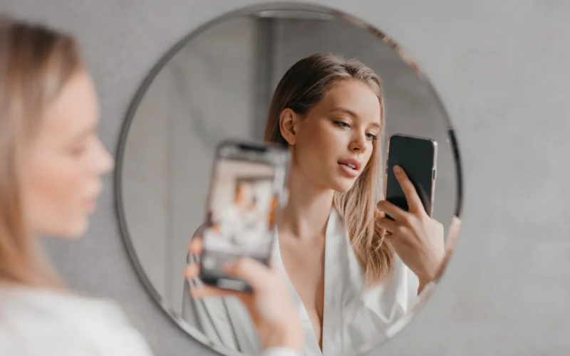 a woman clicking a mirror selfie - self photography, self portrait photograph, self portrait ideas, self portrait photography ideas, portrait photography ideas 