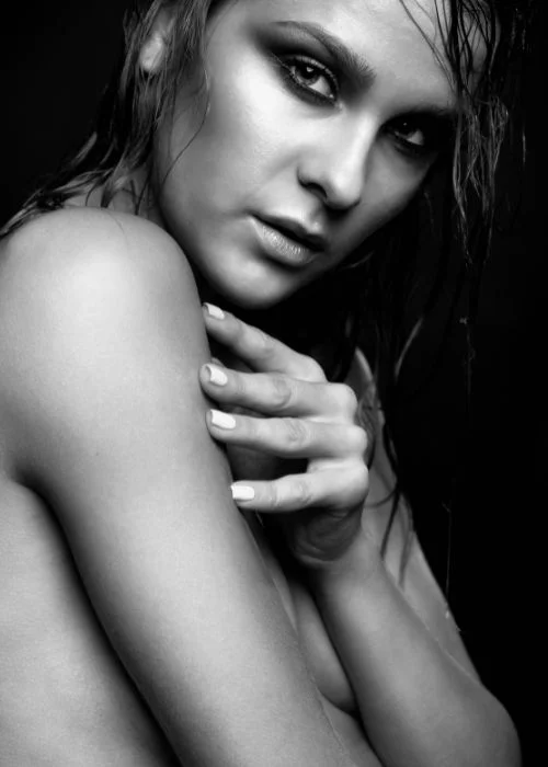 Minimal nude photography setup featuring soft window light and emotional expression