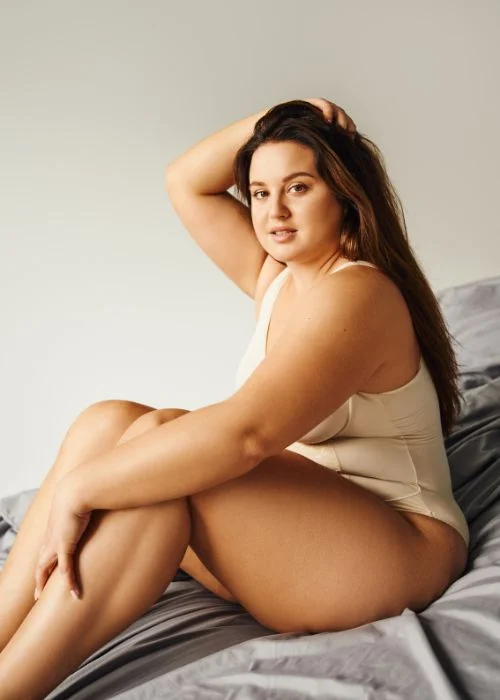 Plus size boudoir portrait with soft lighting and confident natural expression