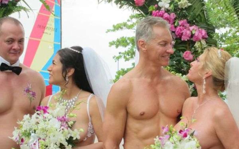 two naked couples on a beach getting married