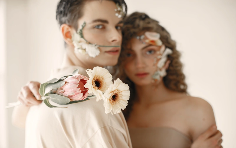 couple adorned with flowers posing for a fine art photoshoot