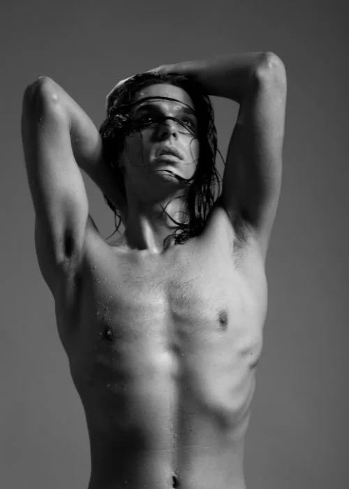 Creative black and white male nude pose highlighting body contours and shadows