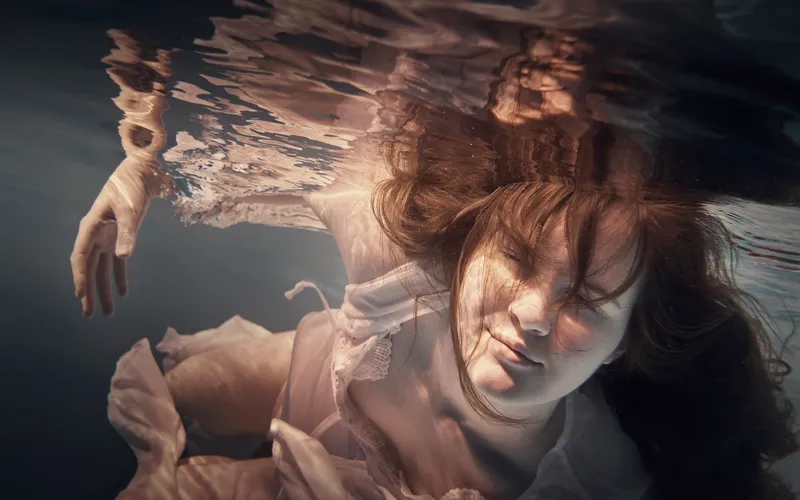 Model's hair flowing freely in an underwater posing composition