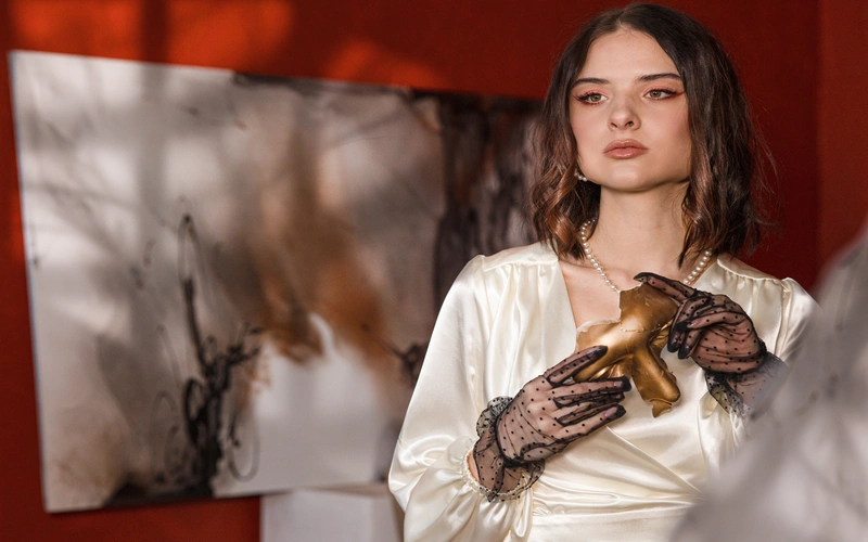 Woman in a white lace top and gloves photographed in soft, even window light