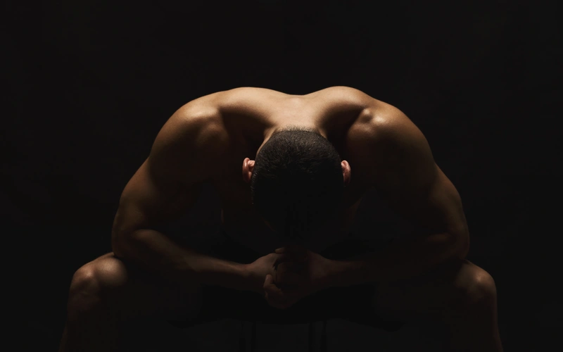 Boudoir pose of a man bending over