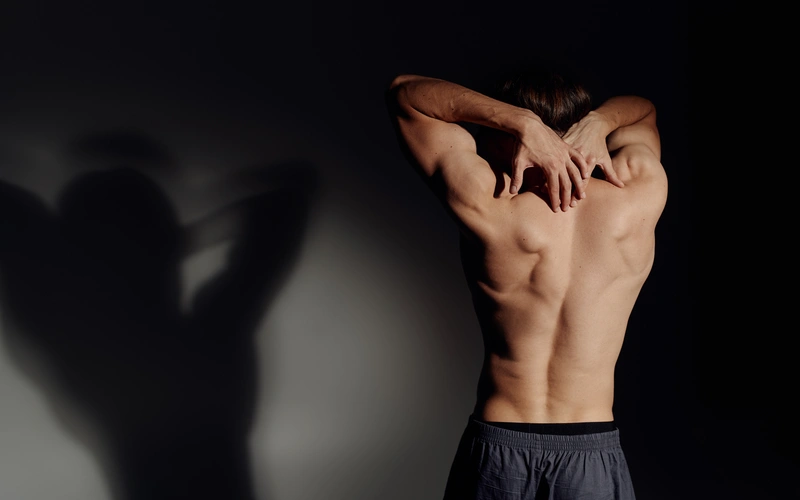 Boudoir photoshoot of a man arching his back
