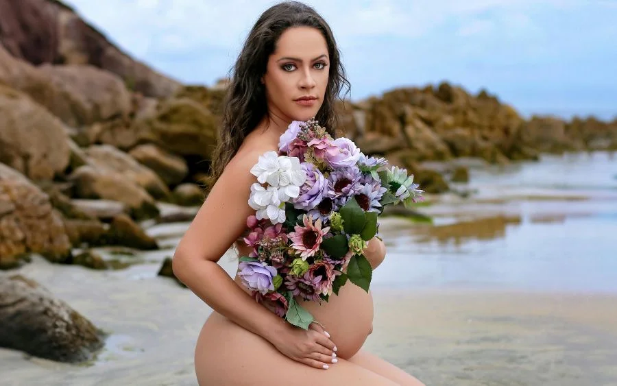 woman posing on a beach with a bouquet