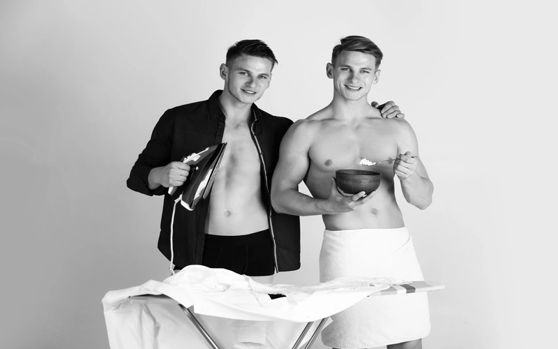 Boudoir photoshoot of two men holding props