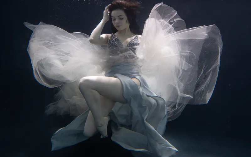 Model posing gracefully underwater during an artistic underwater photoshoot.