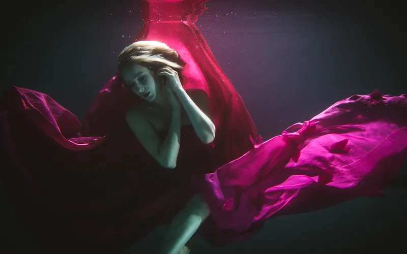 Model extending her arms for an elegant underwater posing silhouette