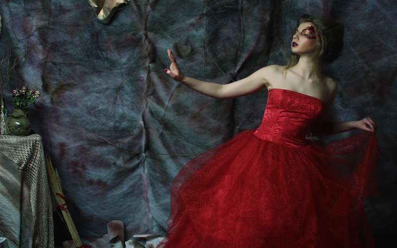 Woman in a dramatic red dress posing for fine art fashion photography