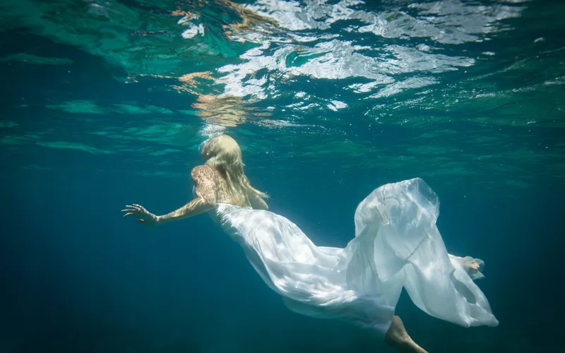 Model posing like a mermaid in a graceful underwater boudoir photoshoot