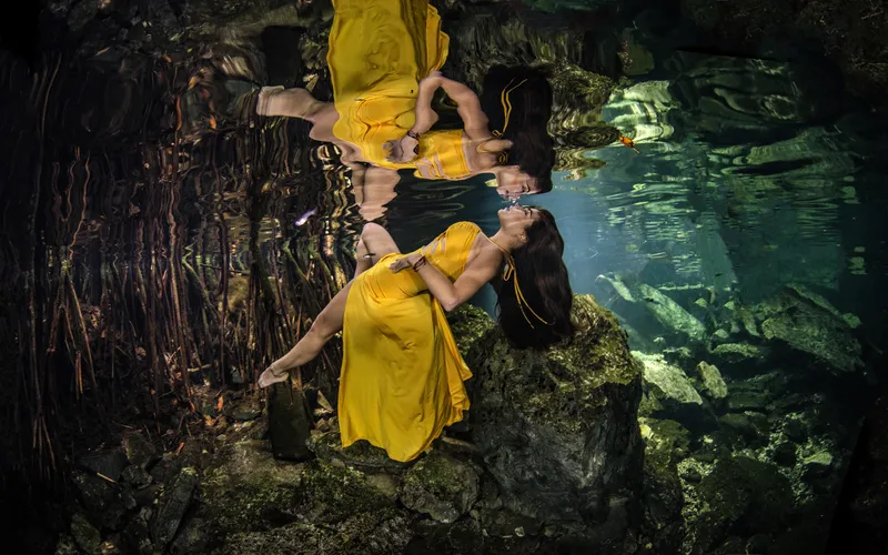 Model's reflection captured on the water's surface in an underwater boudoir photo