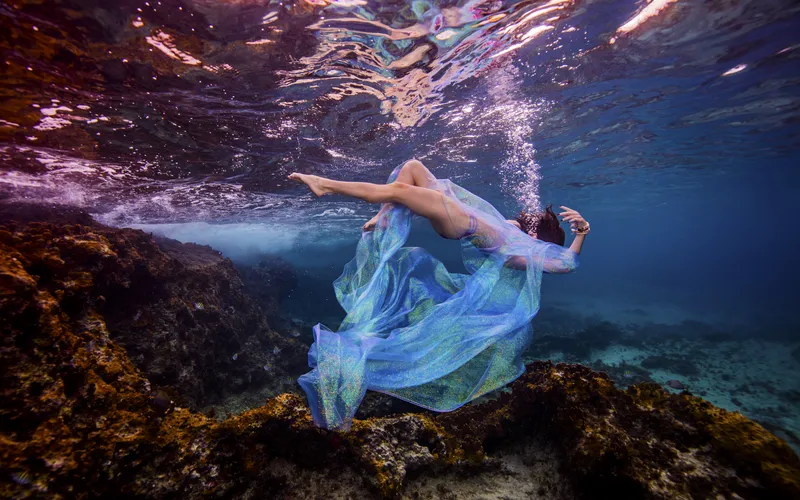Photographer editing an elegant underwater boudoir photography image
