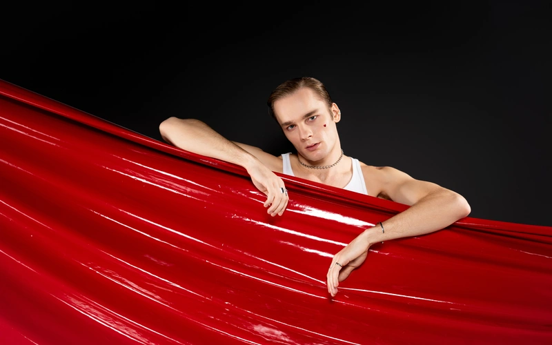 Men's boudoir pose using a fabric