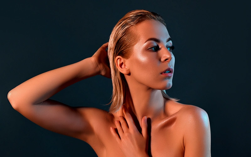 elegant woman posing for her fine art photoshoot against a dark background