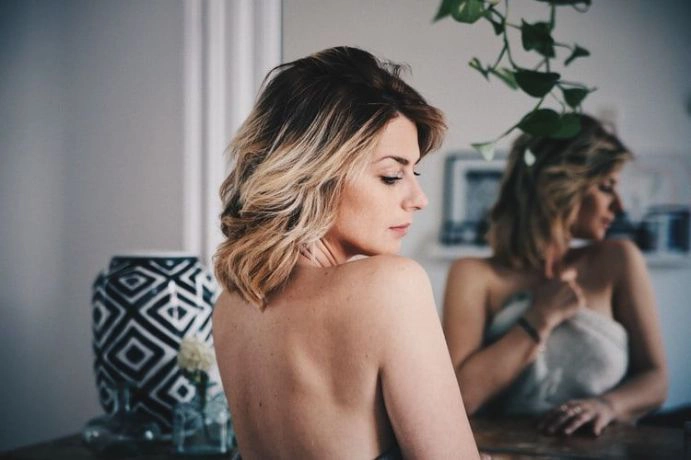 naked woman posing in front of a mirror