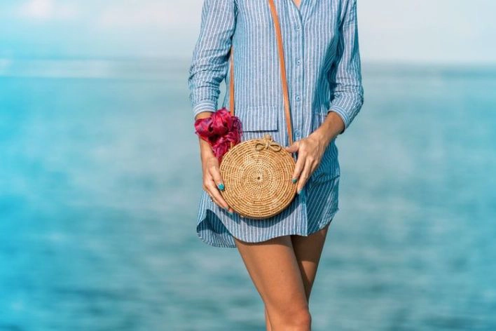 woman on a beach with a handbag