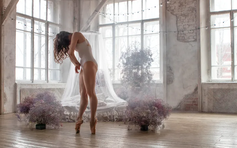 Boudoir bridal portrait of a bride posing against sunlit window