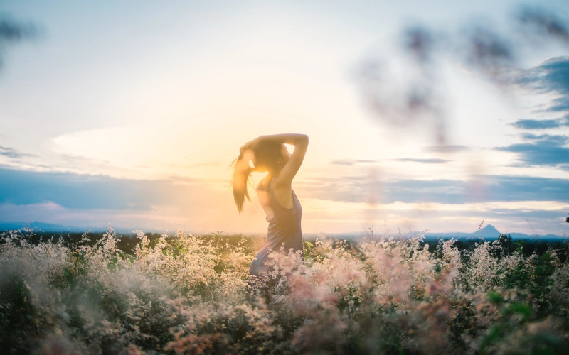 Model posing in warm sunlight for striking figure photography poses.