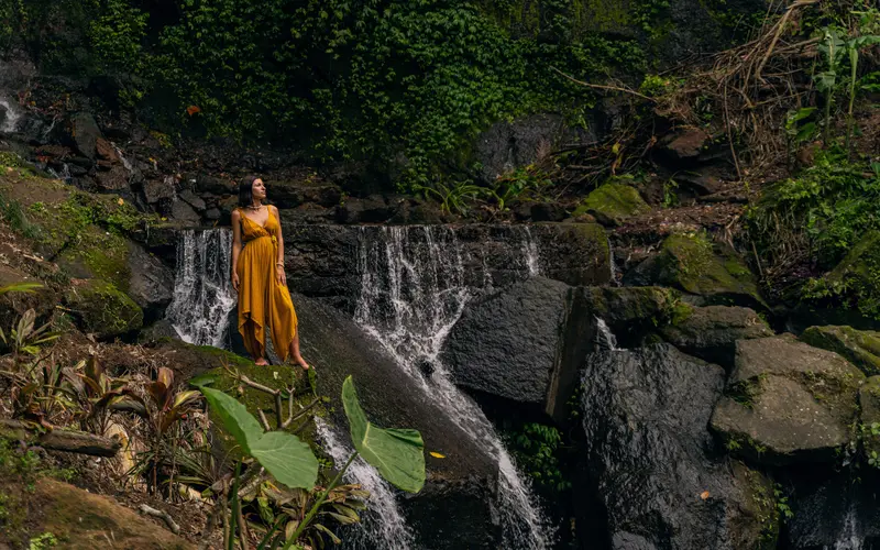 Model posing near a waterfall for dynamic figure photography poses.
