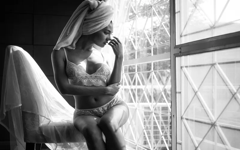 Black and white wedding Boudoir portrait of a bride by a window in soft lace lingerie